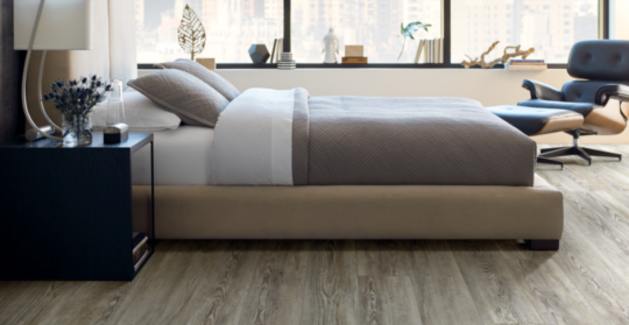 dark wood look luxury vinyl plank in bedroom with contemporary furniture.